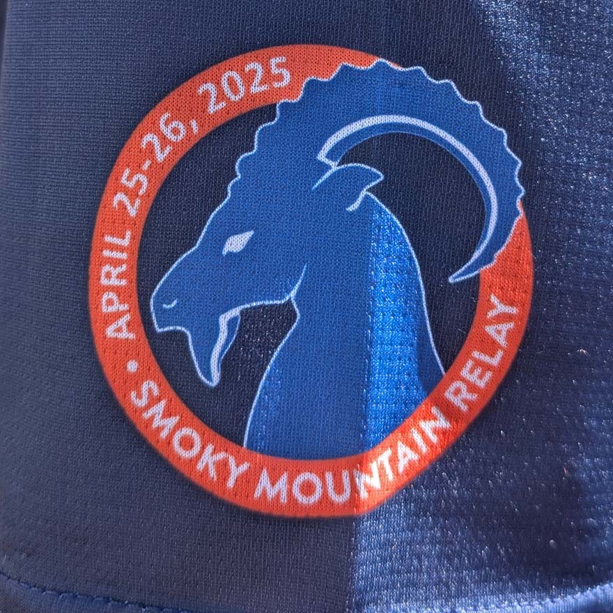 Logo of Smoky Mountain Relay with blue ram in an orange circle on a dark blue background