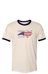 Cream t-shirt with blue cuffs and collar featuring an outline of north Carolina filled with parts of the American flag. The graphic is surrounded by 'Independence Day 5k' and 'Asheville, NC' in ornate text