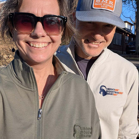Two people wearing branded Smoky Mountain Relay pullovers and hats outdoors.