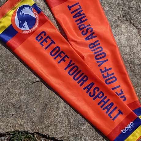 Orange arm sleeves with blue text and Smoky Mountain relay ram logo on a concrete surface