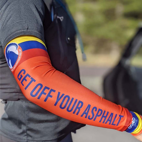 Person wearing an orange arm sleeve with text and a logo, blurred background
