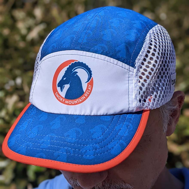 Blue and white cap with a logo on a blurred natural background