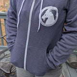 Person wearing a blue hoodie with a SMR ram logo on a deck