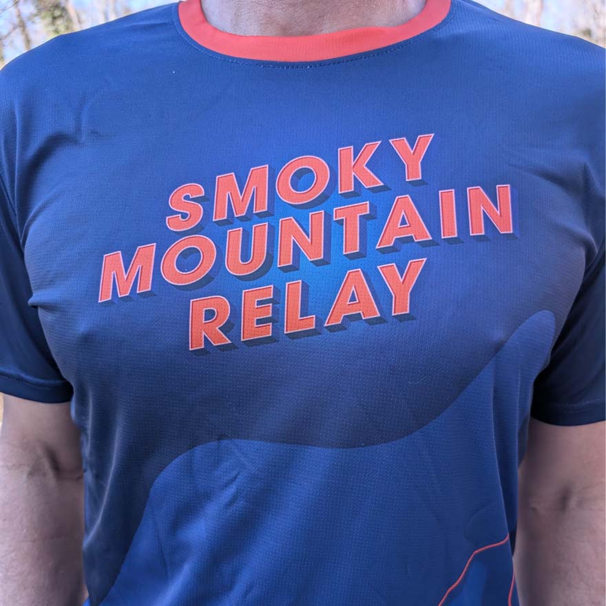 Blue t-shirt with 'Smoky Mountain Relay' text in orange on a person wearing it.